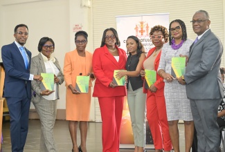 Custos of Manchester, Hon. Garfield Green (right), Regional Director at the Ministry of Education, Skills, Youth and Information, Susan Nelson-Smith (second right), and other officials, display copies of the Constitution of Jamaica, during a ceremony for the reopening of schools in the parish, at deCarteret College in the parish on September 12.
