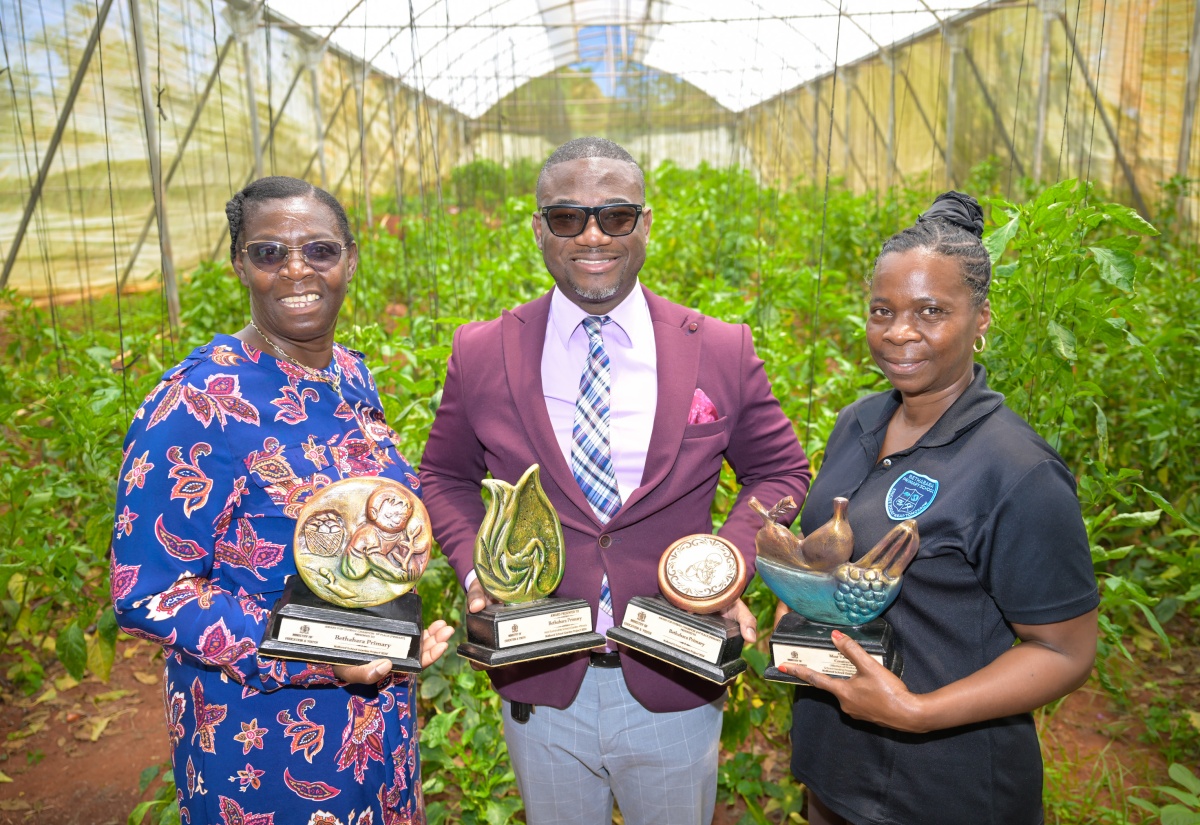Principal of the Manchester-based Bethabara Primary School, Cecil Hamilton (centre), along with Vice Principal, Ritta Evans Lowe, (left), and teacher, Dionne Salkey Francis, display trophies won by the school for its high-quality greenhouse crops and value-added products.


