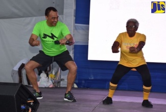 Health and Wellness Minister, Dr. the Hon. Christopher Tufton engages in an exercise session with senior citizen, Gwendolyn Morgan. The Ministry promotes exercise and physical activity as part of a healthy lifestyle habit to combat non-communicable diseases (NCDs), which are risk factors for dementia.