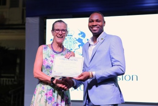 2025 Chevening scholar, Orville Levy (right), receives his certificate from former British High Commissioner to Jamaica, Her Excellency Judith Slater, at a Farewell Reception held at the British High Commissioner's Residence in Kingston, on Tuesday (August 19).


