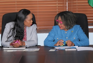 Minister of Education, Skills, Youth and Information, Dr. the Hon. Dana Morris Dixon (right), converses with Permanent Secretary, Dr. Kasan Troupe, during a recent press conference at the Ministry’s National Heroes Circle offices in Kingston.

