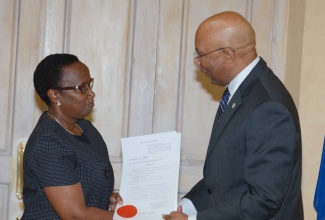 Governor-General, His Excellency the Most Hon. Sir Patrick Allen, presents the Instrument of Appointment to Judge of Appeal, Hon. Justice Paulette Williams, during a ceremony in 2016.