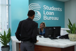 A client interacts with an officer at the Students’ Loan Bureau at its new 86 Hope Road office in Kingston.