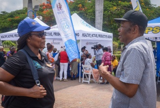 National Council for Senior Citizens (NCSC) Education Programme Organiser, Tamekia Halliman (left), engages in discussion with senior citizen Codgenton Cover, during an Ageing Fair at Emancipation Park in St. Andrew on Thursday (Sept. 11).

