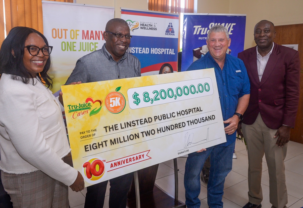 Chief Executive Officer (CEO) of the Linstead Hospital, Camille Wallen-Panton (left), accepts a ceremonial cheque for $8.2 million from Managing Director, Trade Winds Citrus Limited, Peter McConnell (second right). The handover took place at the St. Catherine-based hospital on Tuesday (September 23). Sharing in the moment are St. Catherine Health Services Parish Manager, Abdon Campbell (second left) and Regional Director of the South East Regional Health Authority (SERHA), Lascelles Brown. The funds, raised through the annual Tru-Juice 5K Run/Walk, will assist with the purchase of medical equipment and resources for the hospital
