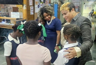 Education, Skills, Youth and Information Minister, Senator Dr. the Hon. Dana Morris Dixon  (left) and State Minister in the Ministry of Health and Wellness, Hon. Krystal Lee (right), share a moment with students from schools in rural St. Andrew. They were at the University Hospital of the West Indies (UHWI) on Tuesday evening (Sept. 23), to visit with students involved in a bus crash along Gordon Town Road.
