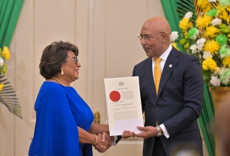 Governor-General, His Excellency the Most Hon. Sir Patrick Allen (right), presents the Instrument of Office to State Minister in the Ministry of Justice and Constitutional Affairs, Hon. Marisa Dalrymple-Philibert, during a swearing-in ceremony held at King’s House on Friday (September 19).