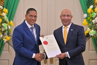 Governor-General, His Excellency the Most Hon. Sir Patrick Allen (right), presents the Instrument of Office to State Minister in the Ministry of Labour and Social Security, Hon. Donovan Williams, during a swearing-in ceremony held at King’s House on Friday (September 19).