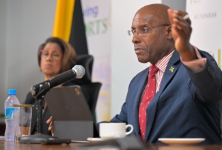 Minister of Industry, Investment and Commerce, Senator the Hon. Aubyn Hill, provides an update on the operations of the Companies Office of Jamaica (COJ) during a press conference at the Ministry’s New Kingston offices, on September 23. At left is Permanent Secretary in the Ministry, Sancia Bennett Templer.