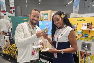 Commissioner General of Section, Jamaica Pavilion at Expo 2025 Osaka, Maureen Smith, and Jamaica Pavilion Director, Kevin Burke, about to take a bite of the Jamaican cheese patty presented by Gangalee Kitchen, at the Jamaica Pavilion, on October 7.

