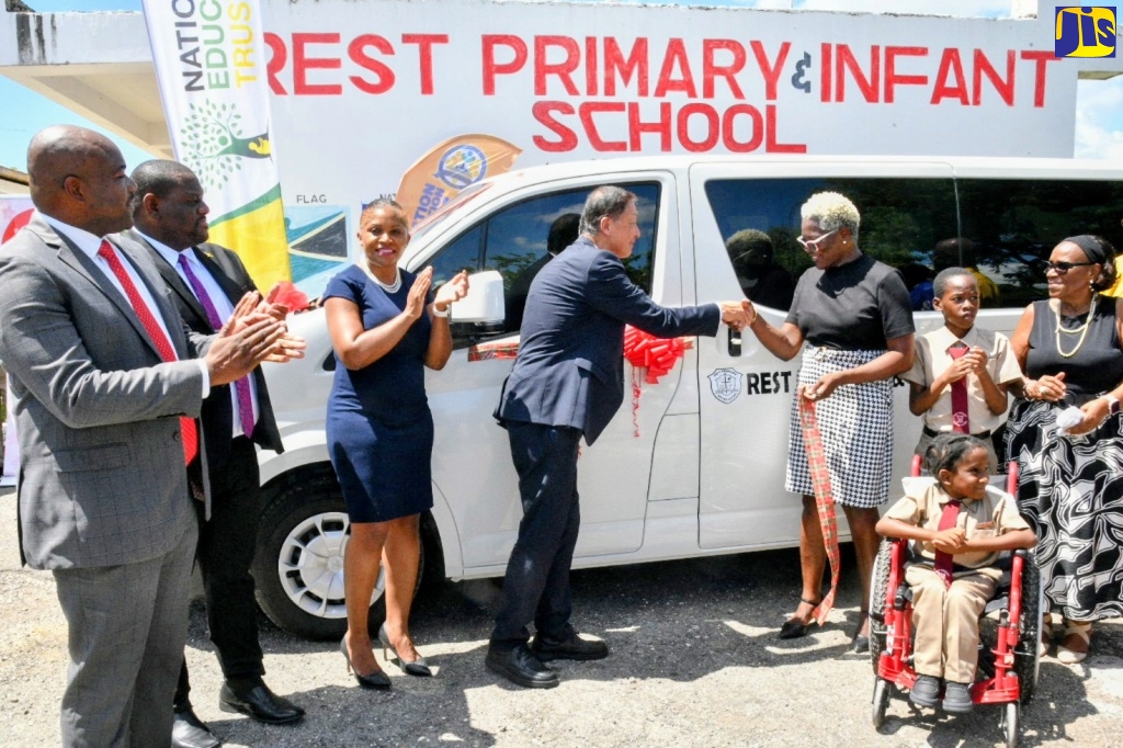 Parliamentary Secretary, Ministry of Education, Skills, Youth and Information, Senator Marlon Morgan (second left), applauds as Ambassador of Japan to Jamaica, His Excellency Yasuhiro Atsumi (4th left), hands over the keys for a bus valued at over US$ 42,000, to Principal of the Clarendon-based Rest Primary and Infant School, Dr. Sandra Smith (4th right), during a ceremony held at the institution on October 2. Other sharing the moment (from left) are: Member of Parliament for Clarendon South Western, Lothan Cousins; Executive Director of the National Education Trust (NET), Latoya Harris-Ghartey; Chairman of the school board, Beverley Boothe; and students.
