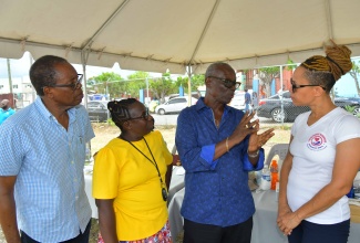 Minister of Local Government and Community Development, Hon. Desmond McKenzie (second right) engages in conversation with Mental Health Officer, Mischelle Callaghan-Graham (right) during the Clarendon Municipal Corporation’s World Homeless Day observance held at the Old Police Station grounds in May Pen, Clarendon on Friday (October 10). Looking on are Mayor of May Pen, Joel Williams (left) and Councillor for the Palmers Cross Division, Carlene Benjamin.