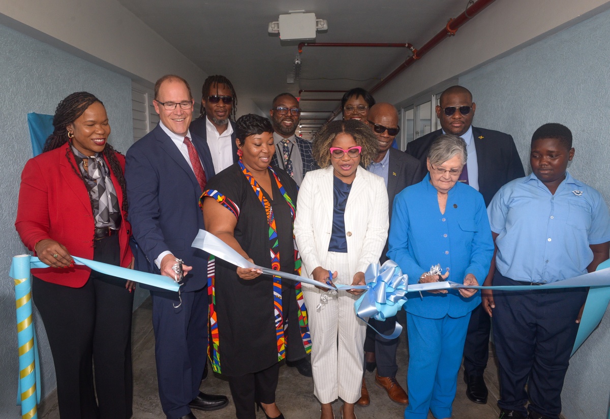 Minister of Education, Skills, Youth and Information, Senator Dr. the Hon. Dana Morris Dixon (front row, fourth left), is joined by (from left) Permanent Secretary, Dr. Kasan Troupe; President and Chief Executive Officer of Christel House International, David Harris; Chief Executive Officer of Christel House Jamaica, Taneshia Stoney Dryden; Co-Founder of Christel House Jamaica, Hon. Sally Porteous; and student, Shavary McFarlane, in the ribbon-cutting ceremony to officially open the high-school building at Christel House Jamaica in Twickenham Park, St. Catherine, on Tuesday (October 7). Observing in the second row (from left) are Councillor for the Spanish Town Division, Christopher Shackleford; Principal, Jason Scott; Acting Chief Education Officer, Terry-Ann Thomas-Gayle; Board Chairman, Hon. Steadman Fuller; and Parliamentary Secretary in the Education Ministry, Senator Marlon Morgan.


