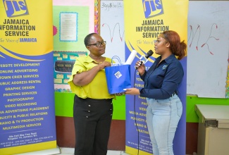Special Projects Officer at the Jamaica Information Service (JIS), Romona Geohaghan (right), presents a package containing books, posters and other publications to Acting Principal at Greenwich Primary School in Kingston, Andrea Richards. The JIS team stopped at the institution on Wednesday (October 1) as part of its annual Heritage School Tour in observance of Heritage Month in October.  The school visits include presentations of heritage materials and cultural displays from students and teachers. 