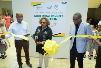 Minister of Culture, Gender, Entertainment and Sport, Hon. Olivia Grange (centre), cuts the ribbon to officially open the Jamaica Cultural Development Commission (JCDC) 2025 Visual Arts Competition Gold Medal Winners Exhibition at the Olympia Art Centre, Old Hope Road, Kingston, on Thursday (October 2) . Sharing the moment are JCDC Executive Director, Lenford Salmon (left), and the JCDC Visual Arts Development Specialist, Dr. Winston Campbell.

