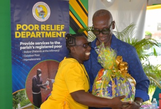 Minister of Local Government and Community Development, Hon. Desmond McKenzie, receives a gift basket by Councillor for the Palmers Cross Division in Clarendon, Carlene Benjamin. The presentation followed the Minister’s address during the Clarendon Municipal Corporation’s observance of World Homeless Day on October 10 at the Old Police Station grounds in May Pen, Clarendon.

