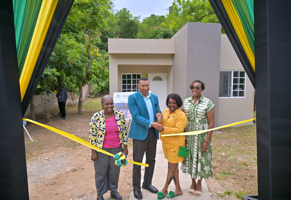 Prime Minister, Dr. the Most Hon. Andrew Holness (second left) and New Social Housing Programme (NSHP) recipient, Denique Groves (second right), cut the ribbon for her new home in Shooters Hill, Bull Bay, St. Andrew, on October 15. Sharing in the moment are Member of Parliament for St. Andrew East Rural, the Most Hon. Juliet Holness (right), and Chair of the NSHP, Judith Robb-Walters.

