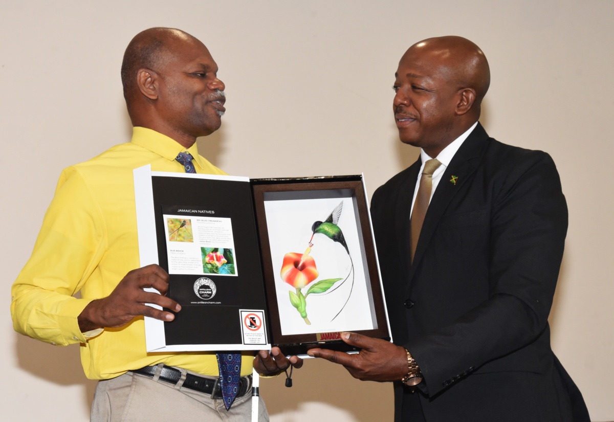 Minister of Labour and Social Security, Hon. Pearnel Charles Jr. (right), receives an art piece from Executive Director of the Jamaica Society for the Blind, Conrad Harris, following his keynote address at a workshop for persons with disabilities on Thursday (October 2), at The Jamaica Pegasus hotel in New Kingston. The session was part of the Caribbean Telecommunications Union (CTU) Information and Communications Technology (ICT) Week 2025.
