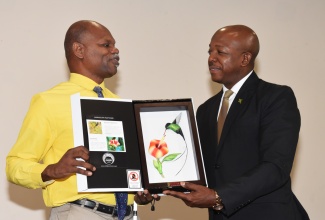 Minister of Labour and Social Security, Hon. Pearnel Charles Jr. (right), receives an art piece from Executive Director of the Jamaica Society for the Blind, Conrad Harris, following his keynote address at a workshop for persons with disabilities on Thursday (October 2), at The Jamaica Pegasus hotel in New Kingston. The session was part of the Caribbean Telecommunications Union (CTU) Information and Communications Technology (ICT) Week 2025.
