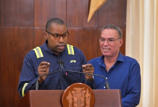 Minister of Energy, Telecommunications and Transportation, Hon. Daryl Vaz (right), listens as Jamaica Public Service Company (JPS) President and Chief Executive Officer, Hugh Grant, outlines the entity’s s operational readiness during a special briefing on Tropical Storm Melissa preparedness, held at Jamaica House on Thursday (October 23).
