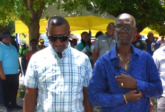 Minister of Local Government and Community Development, Hon. Desmond McKenzie (right) along with Mayor of Kingston, Councillor Andrew Swaby , walk through sections of the Kingston and St. Andrew Municipal Corporation (KSAMC) Wellness in the Park event, held on World Homeless Day, October 10, at the St. William Grant Park in downtown Kingston. The event was hosted by the KSAMC in partnership with the Ministry of Health and Wellness.