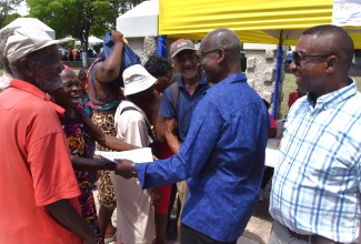 Minister of Local Government and Community Development, Hon. Desmond McKenzie (second right), engages with persons who turned out for the Kingston and St. Andrew Municipal Corporation (KSAMC) Wellness in the Park event held on World Homeless Day on Friday (October 10) at St. William Grant Park in downtown Kingston. Sharing the moment is Mayor of Kingston, Councillor Andrew Swaby (right). The event involved collaboration with the Ministry of Health and Wellness.

