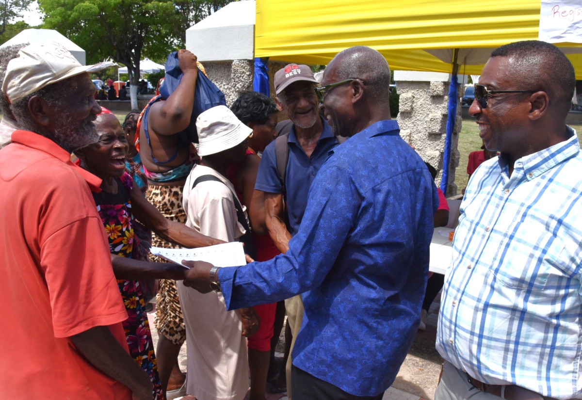 Minister of Local Government and Community Development, Hon. Desmond McKenzie (second right ) engages with patrons during the Kingston and St. Andrew Municipal Corporation (KSAMC) Wellness in the Park event held on World Homeless Day Friday (October 10) at the St. William Grant Park in downtown Kingston. The event was hosted in partnership with the Ministry of Health and Wellness. Sharing in the moment is the Mayor of Kingston, Councillor Andrew Swaby (right).