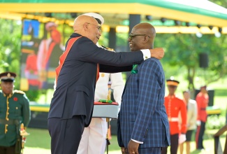Governor-General, His Excellency the Most Hon. Sir Patrick Allen (left), presents the Order of Jamaica (OJ) to Minister of Local Government and Community Development Minister, Hon. Desmond McKenzie, during the Ceremony of Investiture and Presentation of National Honours and Awards 2025, held on the lawns of King's House on National Heroes Day, Monday (Oct. 20).

 