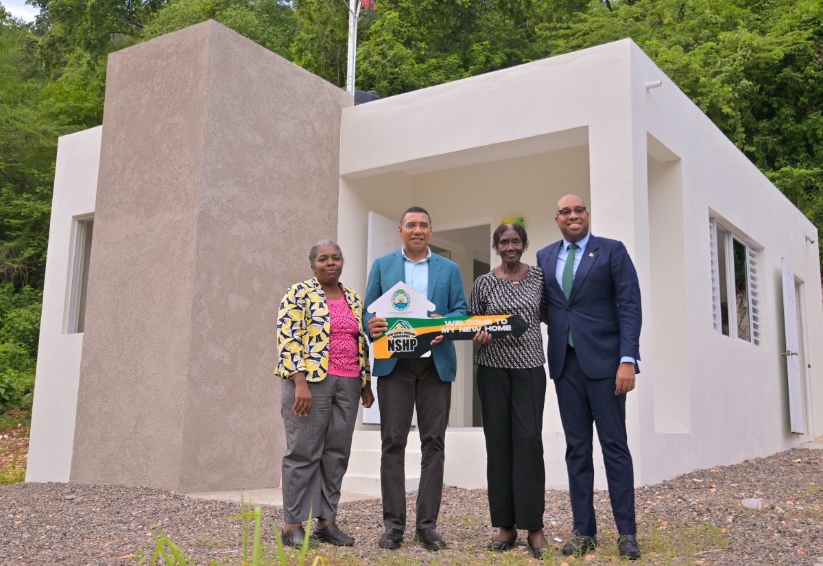 Prime Minister, Dr. the Most Hon. Andrew Holness (second left) presents New Social Housing Programme (NSHP) recipient Gloria Williams (second right) with a symbolic key during the handover of her new home in Red Hills, St. Andrew, on October 15. Sharing in the moment are Member of Parliament for St. Andrew North Central, Hon. Delano Seiveright (right), and Chair of NSHP, Judith Robb-Walters.

