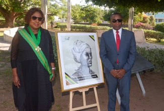 Minister of Culture, Gender, Entertainment and Sport,  Hon. Olivia Grange and Mayor of Kingston, Councillor Andrew Swaby, stand next to framed artwork of Nanny of the Maroons, during Monday