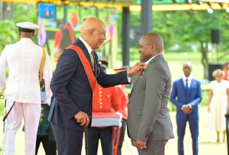 Governor-General, His Excellency the Most Hon. Sir Patrick Allen, presents the Badge of Honour for Long and Faithful Service to Binder at the Jamaica Information Service (JIS), Paul Anthony Johnson, for 38 years of dedicated contribution. Occasion was the Ceremony of Investiture and Presentation of National Honours and Awards at King’s House on Monday (Oct. 20).