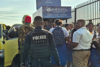An officer from the St. Catherine North Division of the Jamaica Constabulary Force (JCF) monitors students as they board transportation, ensuring they get to school on time as he carries out activities under the ‘Operation Learn, Not Loiter’ initiative.

