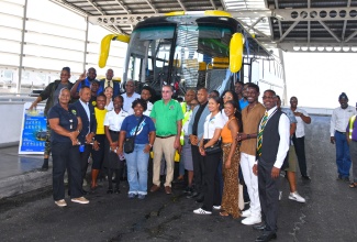 Minister of Transport, Telecommunications, and Energy,  Hon. Daryl Vaz (centre); General Manager for the Half-Way Tree Transport Centre, Keith Blake (second left); and Managing Director of the Jamaica Urban Transit Company (JUTC), Owen Ellington (fifth left), with JUTC team members and representatives from the University of the West Indies (UWI), University of Technology (UTech) Jamaica, lifestyle and travel bloggers, and members of the media, to officially introduce the JUTC Rural Express Service, on Wednesday (October 1) at the Half-Way Tree Transport Centre in Kingston.