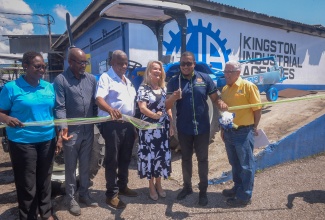 Minister of Agriculture, Fisheries and Mining, Hon. Floyd Green (second right), and Head of the European Union (EU) Delegation to Jamaica, Her Excellency Dr. Erja Askola (third right), cut the ribbon at a handover ceremony for four tractors donated to Jamaica by the EU, today (October 9), at Kingston Industrial Agencies (KIA) on Spanish Town Road in Kingston. Others pictured (from left) are Deputy Director General at the Planning Institute of Jamaica (PIOJ), Claire Bernard; Acting Chief Executive Officer at the Rural Agricultural Development Authority (RADA), Garnet Edmondson; Minister of State in the Ministry, Hon. Franklyn Witter, and Sales Manager at KIA, Stephen Henriques.