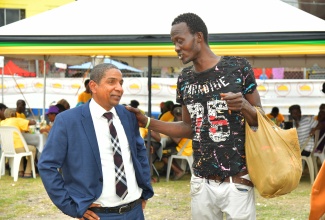 State Minister in the Ministry of Local Government and Community Development, Hon. Delroy Williams (left) engages with Clarendon resident Everton Brown during the Municipal Corporation’s World Homeless Day observance held at the Old Police Station grounds in May Pen, on Friday (October 10).