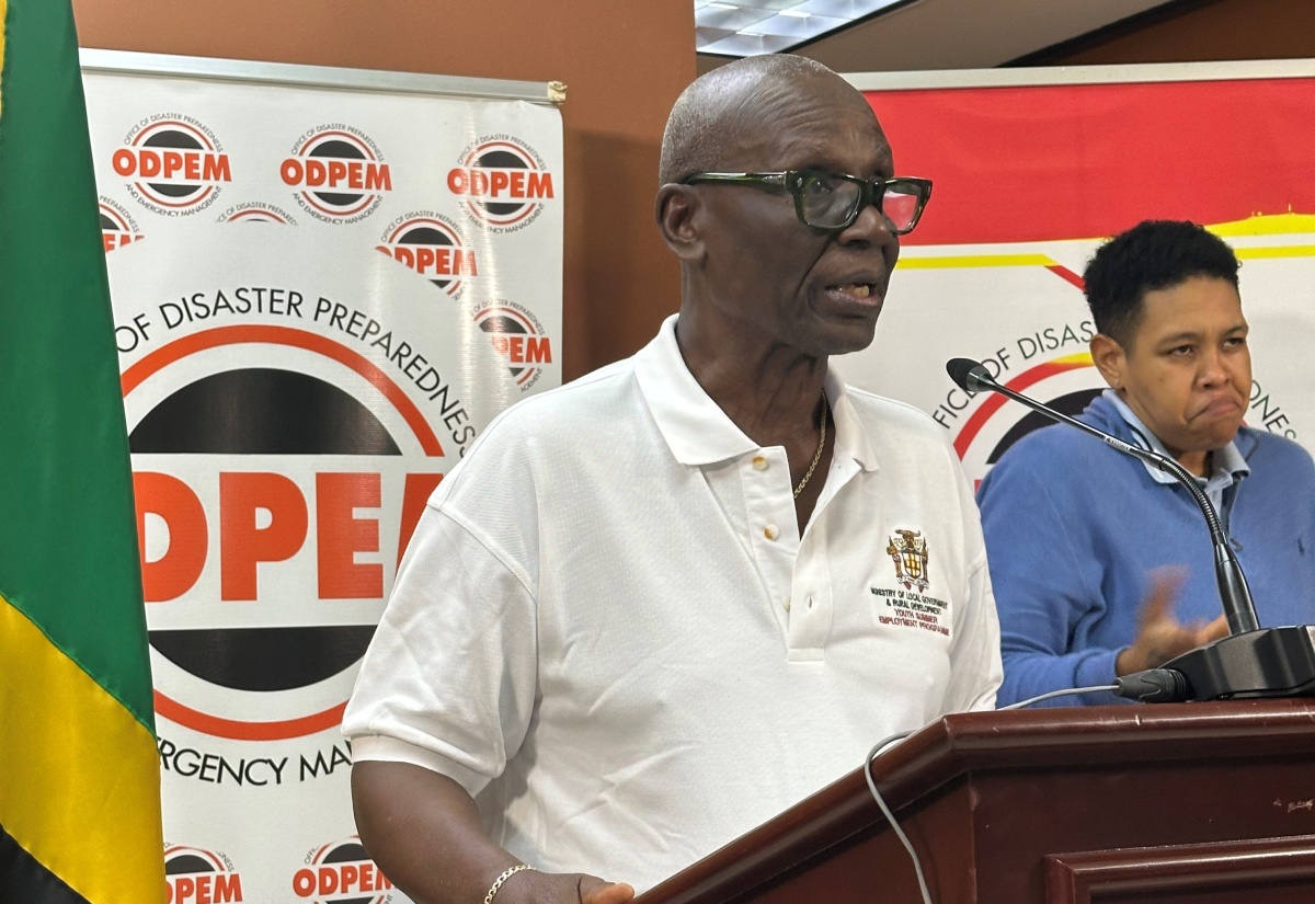 Minister of Local Government and Community Development, Hon. Desmond McKenzie addressing a press briefing at the National Emergency Operations Centre (NEOC) at the Office of Disaster Preparedness and Emergency Management in Kingston on October 28. At right is Sign Language and Spoken English Interpreter, Antoinette Aiken.