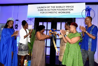 Principal Director in the Ministry of Culture, Gender, Entertainment, and Sport, Sharon Coburn Robinson (third right), assists General Secretary of the Jamaica Household Workers Union (JHWU), Shirley Pryce (third left), in cutting the ribbon to symbolise the launch of the Shirley Pryce Care in Action Foundation for Domestic Workers, during a ceremony earlier this year at the Jamaica Pegasus Hotel in New Kingston. Sharing in the moment (from left) are: Miss Jamaica World 2024, Tahje Bennett; President of the JHWU, Elaine Duncan; Organizing Director at the United States(US)-based We Dream in Black, and National Domestic Workers Alliance, Allison Julien; and Industrial Relations Consultant, Donald Roberts.
 
