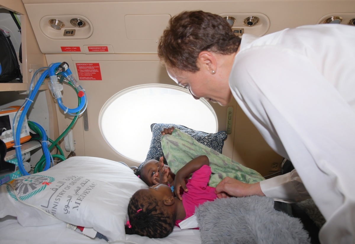 Minister of Foreign Affairs and Foreign Trade, Senator the Hon. Kamina Johnson Smith, shares a moment with conjoined twins, Azora and Azaria Elson, aboard an aircraft at Norman Manley International Airport in Kingston on July 27, ahead of their departure to the Kingdom of Saudi Arabia for separation surgery.

