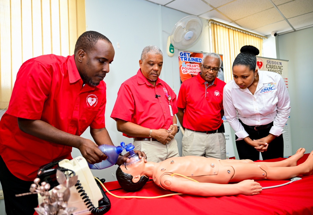 Heart Foundation of Jamaica (HFJ) Training Manager, Alonzo Mothersill (left), demonstrates an emergency procedure on a child mega code, during Wednesday’s (November 26) handover of equipment donated by CHASE Fund at the HFJ