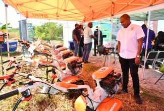 Minister of Agriculture, Fisheries and Mining, Hon. Floyd Green, surveys the walk-behind tractors and earth augers that were handed over in a ceremony on Wednesday (November 26), at the Amity Hall Agro-Park in St. Catherine. The equipment will be distributed in parishes with difficult terrain that were not hard hit by Hurricane Melissa, to assist with the agriculture Ministry’s recovery strategy.