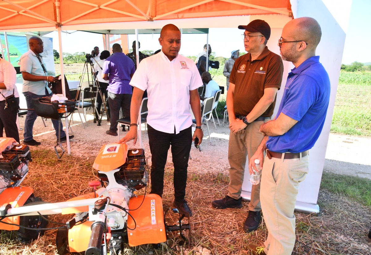 Minister of Agriculture, Fisheries and Mining, Hon. Floyd Green (left), converses with Agri-Invest Corporation (AIC) Chief Executive Officer (CEO), Vivion Scully (centre), and Delta Supply Company Limited Deputy Chaiman, Jonathan Swire, at the handover ceremony for walk-behind tractors and earth augers on Wednesday (November 26) at the Amity Hall Agro-Park in St. Catherine. The equipment will be distributed in parishes with difficult terrain that were not hard hit by Hurricane Melissa, to assist with the Ministry’s recovery strategy.

