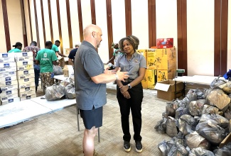 Minister of Education, Skills, Youth and Information, Senator Dr. the Hon. Dana Morris Dixon (right), listens as President of Ground Force Humanitarian Aid, Rob Gaudet, details the organisations plans to help communities in St. James. Occasion was a visit by Senator Morris Dixon to the charity's packing site at the Montego Bay Convention Centre in the parish on Monday ( November 17).  

