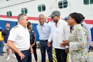 Tourism Minister, Hon Edmund Bartlett (second right), converses with Captain of the ‘Carnival Horizon’, Rocco Lubrano (left), on arrival at the Reynolds Pier, Ocho Rios, St. Ann on Tuesday (November 4) where supplies were handed over to assist with Jamaica’s Hurricane Melissa relief efforts. Others (from second left) are President and Chief Executive Officer of the Port Authority of Jamaica (PAJ) Professor Gordon Shirley; and Carnival Corporation Senior Executive, Marie McKenzie.

