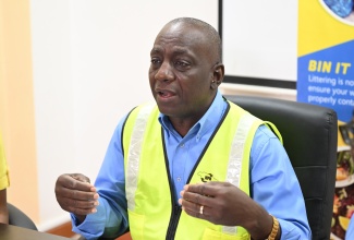 Executive Director of the National Solid Waste Management Authority (NSWMA), Audley Gordon (centre), addresses a press briefing at the WPM Waste Management Limited headquarters in Ironshore, St. James, on Monday (November 11).

