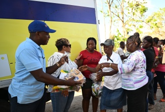 Minister of Labour and Social Security, Hon. Pearnel Charles Jr., is joined by State Minister in the Ministry of Health and Wellness and Member of Parliament for St. Ann North Western, Hon. Krystal Lee (second left), as they hand out care packages to residents of Sturge Town in the constituency on Wednesday (November 19), in support of Hurricane Melissa recovery efforts.