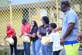 Digicel representatives are joined by a student and parent in offloading relief packages to benefit parents of special needs students at the Catherine Hall Primary School. The handover took place at the Catherine Hall Primary School
