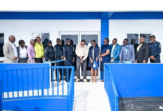 Prime Minister, Dr. the Hon. Andrew Holness (seventh right), cuts the ribbon to officially open the new Little London Police Station in Westmoreland on Friday (November 28). He was joined by Minister of State in the Ministry of National Security and Peace, Hon. Juliet Cuthbert-Flynn (sixth right); Permanent Secretary, Ambassador Alison Stone Roofe (fifth right); Commanding Officer for Westmoreland Division, Senior Superintendent of Police Othneil Dobson (sixth left); and Deputy Commissioner of Police Karina Powell-Hood, along with other officials and stakeholders.