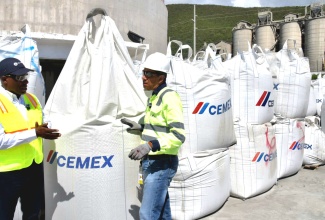 Minister of Industry, Investment and Commerce, Senator the Hon. Aubyn Hill (left) and Caribbean Cement Company Limited (CCCL) General Manager, Jorge Martinez (right) converses about the production of cement during a tour of the company’s plant in Rockfort, Kingston on Friday (November 7). The tour was conducted to view the production of cement.