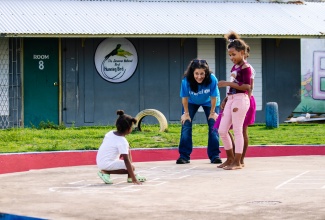 Education Specialist at the United Nations Children’s Fund (UNICEF) Jamaica, Dr. Rebecca Tortello,  interacts warmly with children as she shares a meaningful moment with them.

