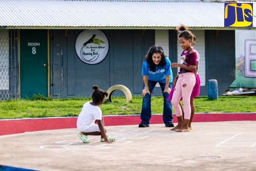 Education Specialist at the United Nations Children’s Fund (UNICEF) Jamaica, Dr. Rebecca Tortello, interacts warmly with children as she shares a meaningful moment with them.